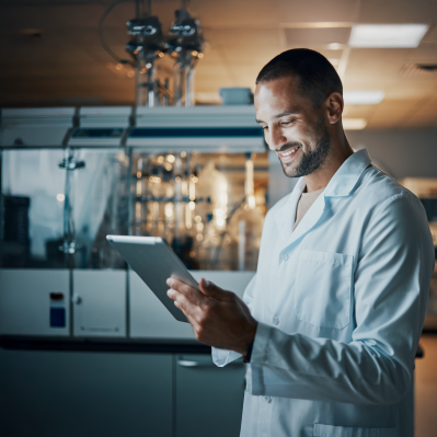 Scientist in a lab coat reviewing amino acid analysis data on a digital tablet in a chromatography laboratory.